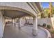Spacious covered patio with stone columns, built-in grill, and manicured landscaping, ideal for outdoor entertaining at 8864 La Manga Ave, Las Vegas, NV 89147