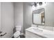 Well lit half bathroom with grey walls, white vanity and marble countertop, and black hardware at 8864 La Manga Ave, Las Vegas, NV 89147