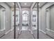 Hallway view of a modern bathroom featuring dual vanities, a soaking tub, a window and modern lighting at 8864 La Manga Ave, Las Vegas, NV 89147