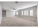 The bonus room features neutral carpet, grey walls, ceiling fan, and plenty of natural light at 8864 La Manga Ave, Las Vegas, NV 89147