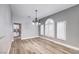 Open floor plan dining area has hardwood floors, light gray walls, and a modern chandelier at 8864 La Manga Ave, Las Vegas, NV 89147