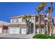 Beautiful two-story home featuring a three-car garage, lush lawn, and mature palm trees at 8864 La Manga Ave, Las Vegas, NV 89147