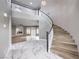 Elegant foyer featuring a staircase and marble flooring, leading into a bright living area at 8864 La Manga Ave, Las Vegas, NV 89147