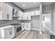 White kitchen features stainless steel appliances and stone backsplash at 8864 La Manga Ave, Las Vegas, NV 89147