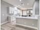 Modern kitchen features sleek white cabinets, stone backsplash, and an island with counter seating at 8864 La Manga Ave, Las Vegas, NV 89147