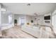 Open concept living room with fireplace, white sofa, and light wood flooring at 8864 La Manga Ave, Las Vegas, NV 89147