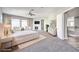 The main bedroom includes carpet flooring, a ceiling fan, multiple windows, two chairs, a fireplace and a TV at 8864 La Manga Ave, Las Vegas, NV 89147