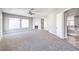 The main bedroom is an empty space that includes carpet flooring, a ceiling fan, multiple windows and a fireplace at 8864 La Manga Ave, Las Vegas, NV 89147
