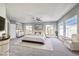 The main bedroom has multiple windows, carpet flooring, a ceiling fan, and is furnished with a bed, dresser and chair at 8864 La Manga Ave, Las Vegas, NV 89147