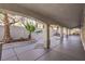 Exterior view of the covered patio with arched openings, concrete flooring and landscaping at 8864 La Manga Ave, Las Vegas, NV 89147
