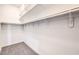 An empty walk-in closet with carpet flooring, white walls, and multiple shelves and bars at 8864 La Manga Ave, Las Vegas, NV 89147
