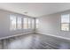 Spacious bedroom featuring three large windows with gray wood-style laminate flooring at 9071 Mount Wilson St, Las Vegas, NV 89113