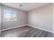 A vacant bedroom features wood floors, neutral gray paint, white trim, and a window for natural light at 9071 Mount Wilson St, Las Vegas, NV 89113