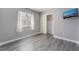 Bedroom with wood flooring, white trim and base molding and a television mounted on the wall at 9071 Mount Wilson St, Las Vegas, NV 89113