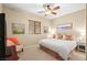 This bedroom has a queen bed, a ceiling fan, natural light, and is decorated with art and decor at 9172 Tudor Park Pl, Las Vegas, NV 89145
