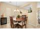 Bright dining area offers a wood table, seating for six, glass block windows, and decorative lighting at 9172 Tudor Park Pl, Las Vegas, NV 89145