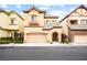Charming two-story home featuring tan stucco, arched entryway, and convenient two-car garage at 9172 Tudor Park Pl, Las Vegas, NV 89145