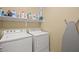 Functional laundry room with a washer and dryer and built-in shelving at 9172 Tudor Park Pl, Las Vegas, NV 89145