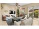 Comfortable living room featuring neutral walls, plush seating, ceiling fan, and sliding door to patio at 9172 Tudor Park Pl, Las Vegas, NV 89145
