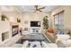 Comfortable living room with a fireplace, plush seating, ceiling fan, and neutral decor at 9172 Tudor Park Pl, Las Vegas, NV 89145