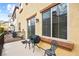 Cozy patio featuring a grill, bistro set, and large window, enhancing outdoor living and natural light at 9172 Tudor Park Pl, Las Vegas, NV 89145