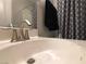 Bright bathroom featuring a modern sink, faucet, and decorative shower curtain at 9359 Brigham Ave, Las Vegas, NV 89178