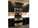 Modern kitchen features sleek black cabinets, stainless steel appliances, and bright countertops at 9359 Brigham Ave, Las Vegas, NV 89178