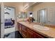 Another view of the bathroom with dual sinks, a tile countertop, and dark wood cabinets, leading to the bedroom and shower at 949 Via Stellato St, Henderson, NV 89011