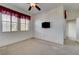 Simple carpeted bedroom with a wall mounted TV and window at 949 Via Stellato St, Henderson, NV 89011