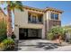 Two-story home with stucco and stone accents, featuring a balcony, two-car garage, and desert landscaping at 949 Via Stellato St, Henderson, NV 89011