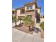 Charming two-story home with stone accents, a balcony, desert landscaping, and a pedestrian gate at 949 Via Stellato St, Henderson, NV 89011