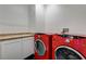 Laundry area with tiled countertops and side by side red washer and dryer at 949 Via Stellato St, Henderson, NV 89011