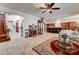 Elegant living room with travertine flooring, a ceiling fan, and a view into the kitchen at 949 Via Stellato St, Henderson, NV 89011