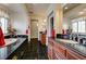 Elegant bathroom featuring black granite countertops, wooden cabinets and black tile floors at 949 Via Stellato St, Henderson, NV 89011