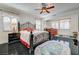 Luxurious main bedroom with black tile floors, a wrought iron bed frame, ceiling fan and natural light at 949 Via Stellato St, Henderson, NV 89011