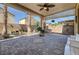 Spacious covered patio featuring brick pavers, ceiling fans, columns, bench seating, and lush greenery at 949 Via Stellato St, Henderson, NV 89011