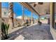 Spacious covered patio featuring brick pavers, ceiling fans, columns, lush greenery, and bench seating at 949 Via Stellato St, Henderson, NV 89011