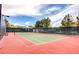 Fenced tennis court with green and red surfaces, ready for a match at 949 Via Stellato St, Henderson, NV 89011