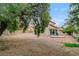 Backyard featuring mature trees, partial patio, rock landscaping, and home exterior at 9529 Shallow Brook Cir, Las Vegas, NV 89117
