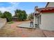 View of the backyard with partial patio, gravel, mature tree, and grill at 9529 Shallow Brook Cir, Las Vegas, NV 89117