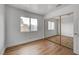 Bedroom with hardwood floors, mirrored closet, and a bright window at 9529 Shallow Brook Cir, Las Vegas, NV 89117