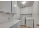 Bright laundry room with white cabinetry, countertop space, and included washer and dryer at 9529 Shallow Brook Cir, Las Vegas, NV 89117