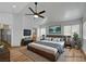 This is a virtually staged main bedroom with wood floors, ceiling fan, TV, and ensuite bathroom at 9529 Shallow Brook Cir, Las Vegas, NV 89117