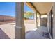 Covered patio with views of the backyard that is enclosed by a brick wall, gravel and brick-paver ground cover and trees at 9617 Fast Elk St, Las Vegas, NV 89143