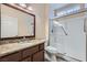 Elegant bathroom featuring a granite countertop, framed mirror, and glass shower with grab bars at 9920 Netherton Dr, Las Vegas, NV 89134