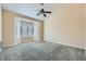 Bedroom with neutral carpeting, ceiling fan and bright, shuttered windows at 9920 Netherton Dr, Las Vegas, NV 89134