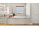 Bright bathroom features soaking tub, shower, and window with backyard view at 10133 Longoria St, Las Vegas, NV 89178