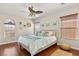 Bedroom with wood floor, natural light from the windows, ceiling fan, and decor at 10133 Longoria St, Las Vegas, NV 89178