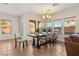 Dining room with tiled floors, modern chandelier, and multiple windows providing ample natural light at 10133 Longoria St, Las Vegas, NV 89178