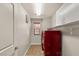 This is a bright laundry room with red washer and dryer units, cabinets, tile floor, and a small window at 10133 Longoria St, Las Vegas, NV 89178